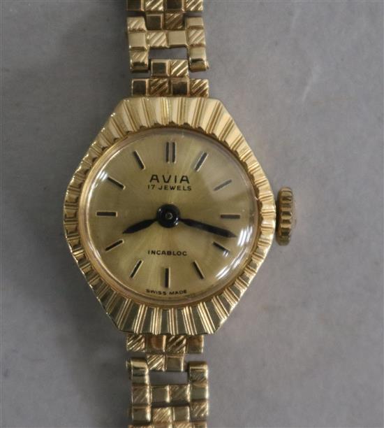 A ladys 9ct gold Avia manual wind wrist watch on a 9ct gold bracelet.
